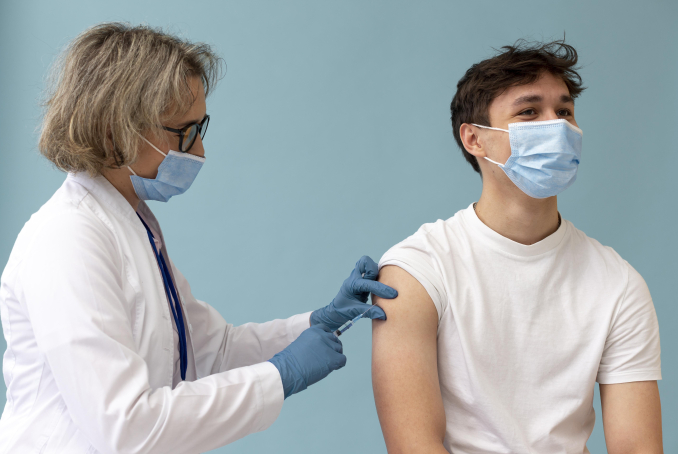 Un adolescent recevant une injection d'un vaccin par un professionnel de santé.