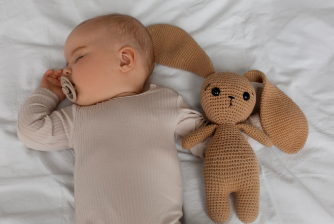 Visuel d'un bébé avec son doudou