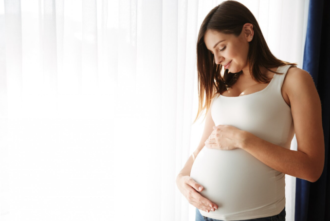 Visuel d'une femme enceinte tenant son ventre entre ses mains