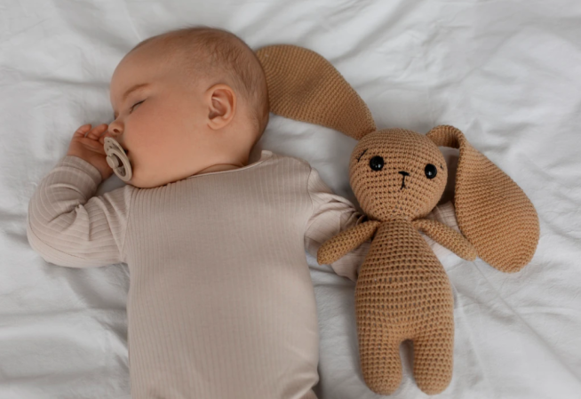 Visuel d'un bébé avec son doudou
