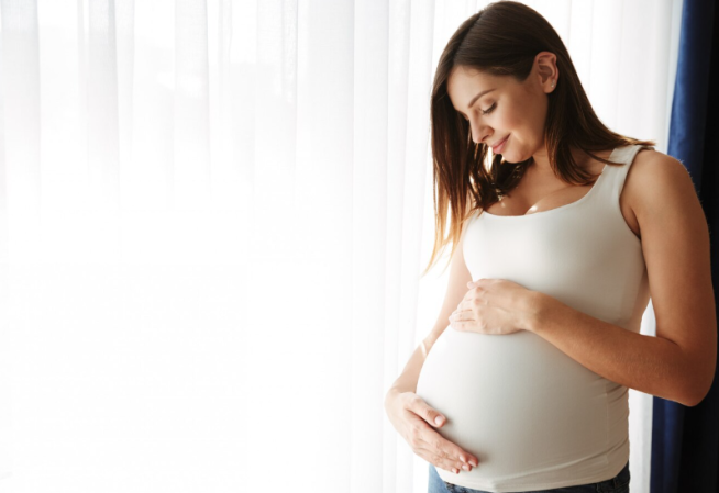 Visuel d'une femme enceinte tenant son ventre entre ses mains